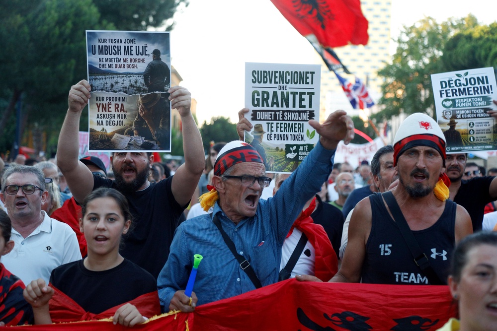 Protesters hold placards and wave the national flag of Albania as they demonstrate (AFP/Getty)