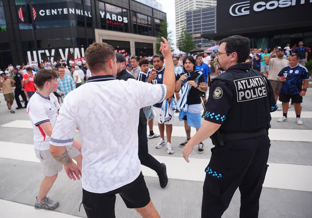 A police officer breaks up an argument between Argentina and England supporters as they leave the Atlanta Stadium (PA)