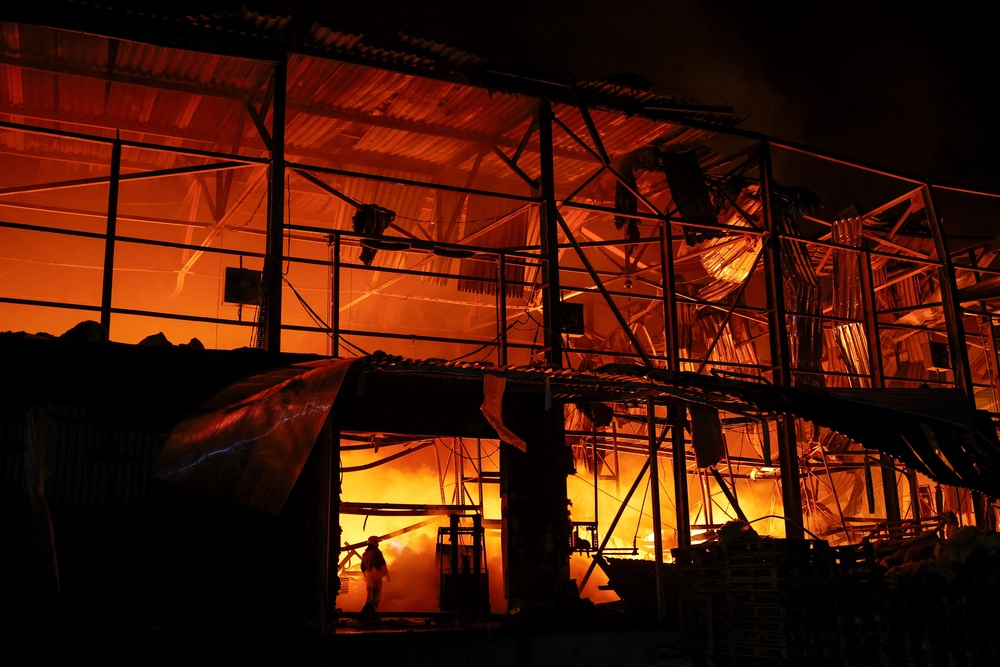 Firefighters work at a compound of a warehouse damaged during Russian missile strikes, amid Russia's attack on Ukraine, in Kyiv (Reuters)