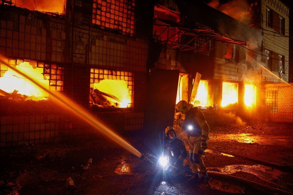 Firefighters work at a compound of a private enterprise damaged during Russian missile strikes, amid Russia's attack on Ukraine, in Kyiv (Reuters)