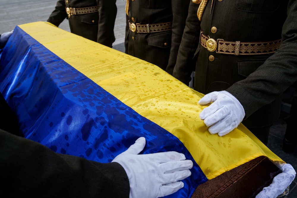 An honor guard straightens out the flag draped over the coffin of a unidentified Ukrainian soldier killed in battle during the Russian-Ukrainian war (AP Photo/Evgeniy Maloletka) (Copyright 2026 The Associated Press. All rights reserved)