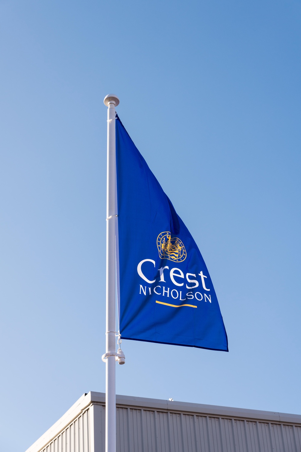 R4KW2A Crest Nicholson house builders blue flag flying on construction site in Birmingham