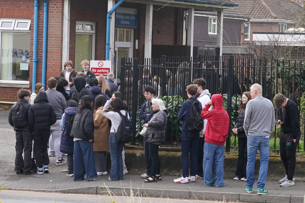 People wait in line outside a meningitis vaccination hub at the Vicarage Lane Clinic in Ashford, Kent (PA Wire)