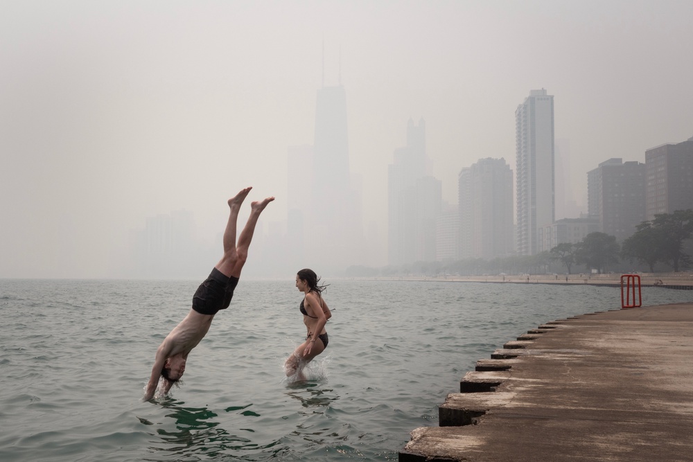 Smoke from Canadian wildfires settles in on the lakefront as Emma Kristin and Joshua Nieman cool off in Lake Michigan on July 16, 2026 in Chicago, Illinois. (Getty)