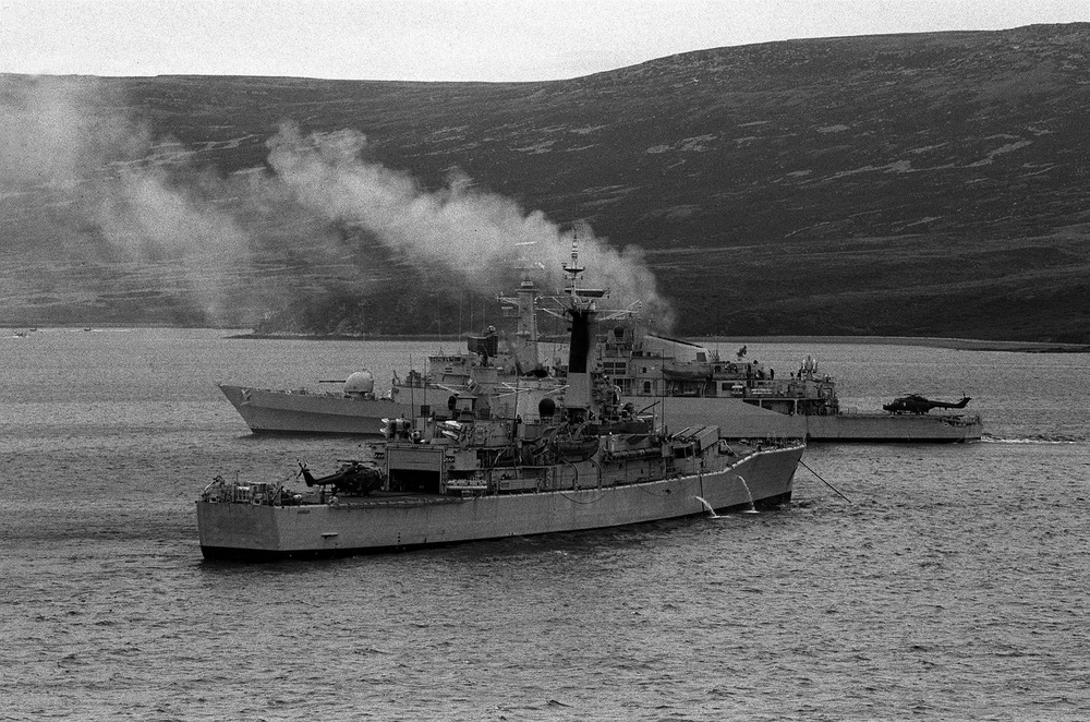 A Royal Navy ship moored near HMS Antelope (background) in Ajax Bay the day before she exploded and sank. Antelope was hit by an Argentinian Exocet missile which later exploded while an attempt was being made to defuse it (PA)