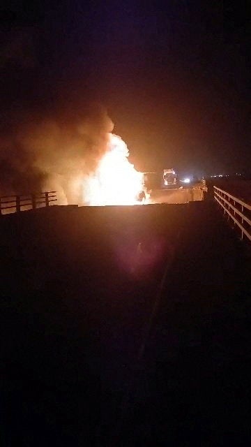 A fire burns on a damaged bridge in the aftermath of a strike, in Bandar Khamir (Reuters)