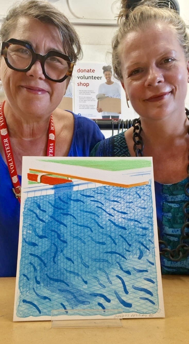 Jemma Banks and shop manager Maria Zacharias with the print and book (Salvation Army Trading Company)