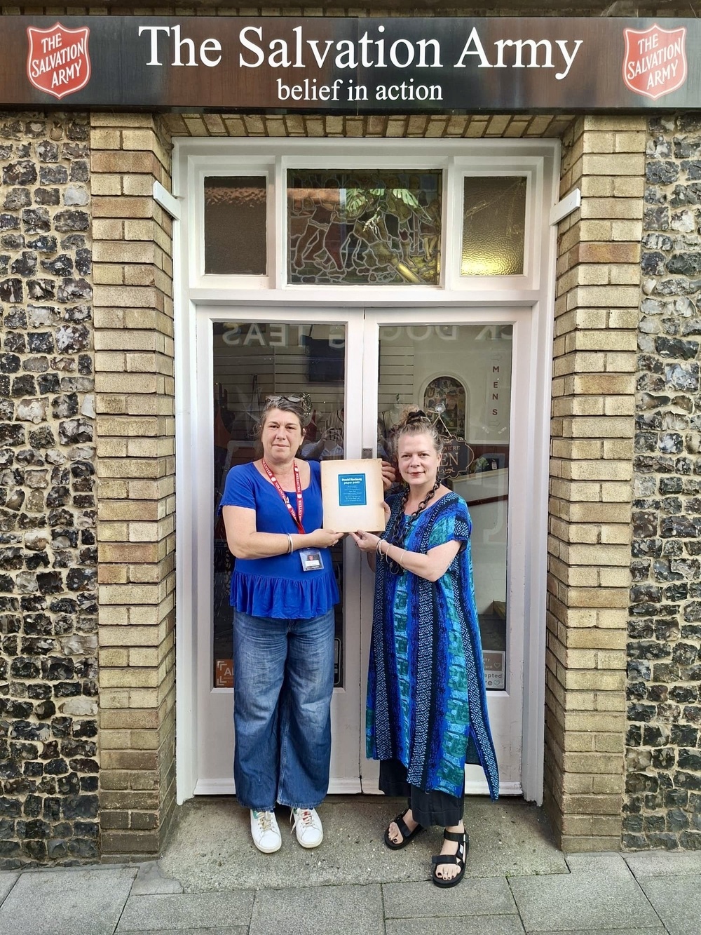 Jemma Banks and shop manager Maria Zacharias with the print and book (Salvation Army Trading Company)