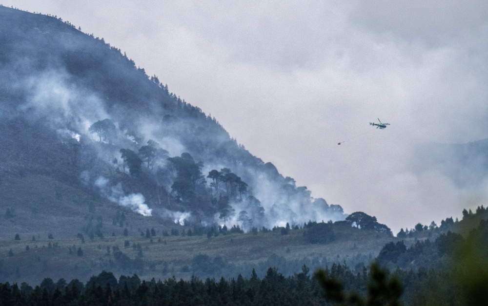 A helicopter carrying water tackles the wildfire burning near Nethy Bridge in Cairngorms National Park in north-east Scotland (Jane Barlow/PA) (PA Wire)