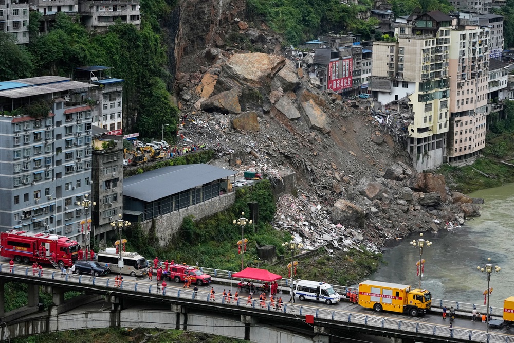 At least eight were killed and 34 remained missing after a rain-triggered landslide buried more than 10 residential buildings in China (AP)