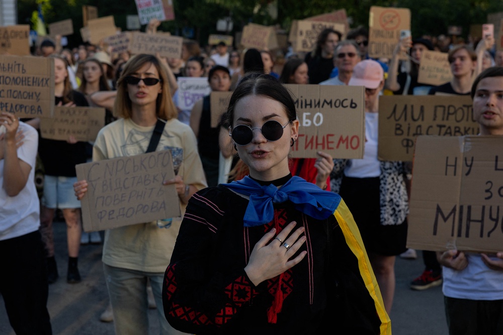 Protesters hold placards and chant slogans during a demonstration against Ukraine's president's decision to dismiss Ukraine's defence minister in Kyiv (AFP/Getty)