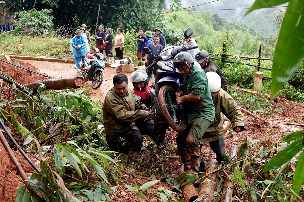 People carry a motorbike across a landslide site in Lao Cai Province, northern Vietnam (AFP/Getty)