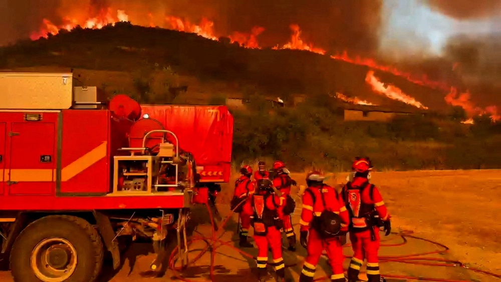Firefighters work at a site following a wildfire in the municipality of Ores on Wednesday (Reuters)