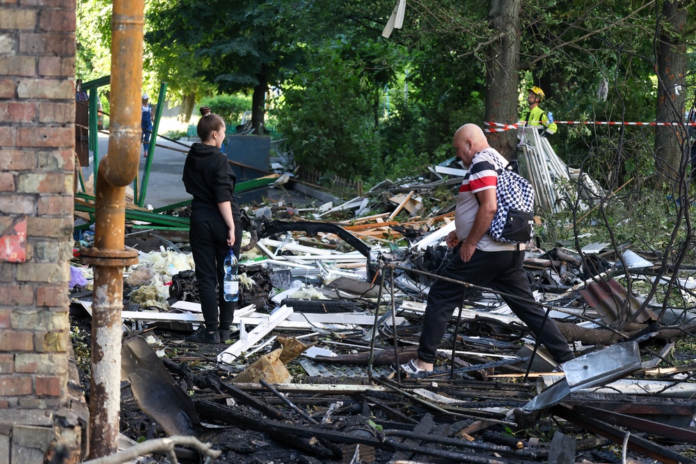 Local residents stand outside a residential building damaged by a Russian missile strikes in Kyiv (AFP/Getty)