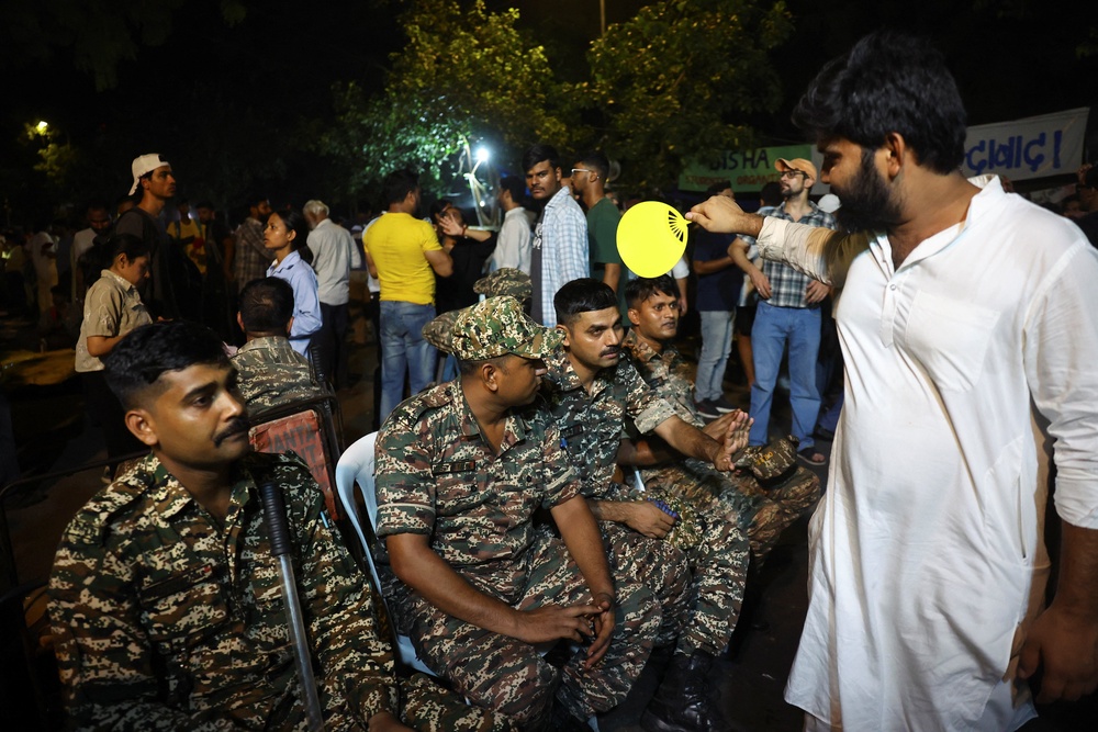 A supporter of the Cockroach Janta Party (CJP) fans members of the Central Reserve Police Force (CRPF) (Reuters)