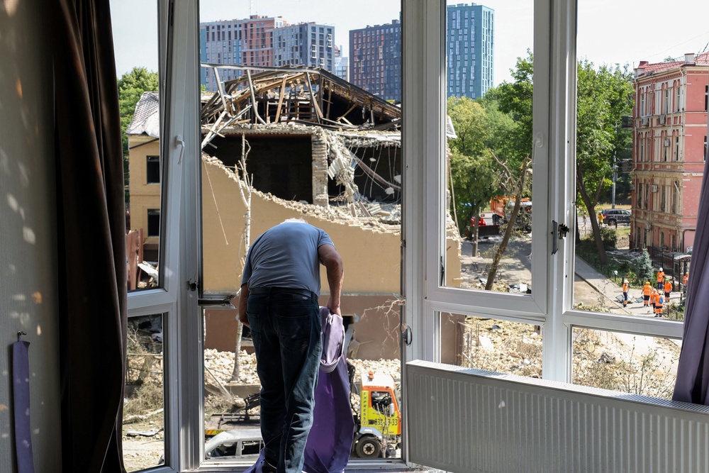 A local resident cleans his damaged apartment (AFP/Getty)