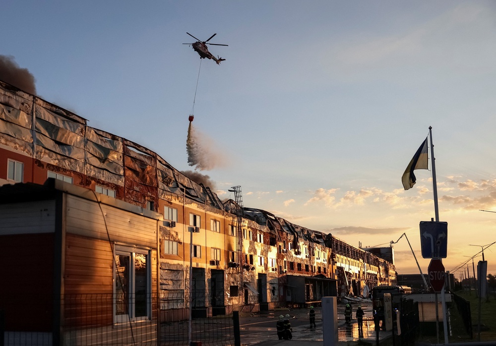 A firefighting helicopter drops water over the site of a Russian missile strike in Kyiv (Reuters)