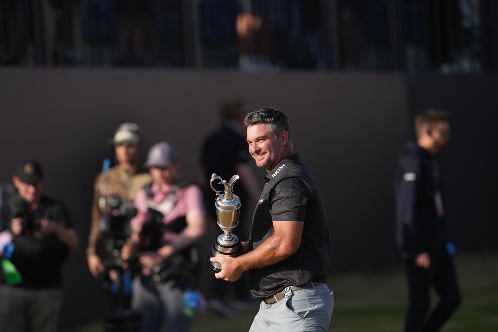 Ryan Fox of New Zealand walks around the 18th green as he poses with the Claret Jug trophy (AP)