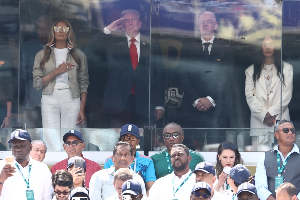 Trump, his wife Melania, and FIFA’s president listen to the National Anthem’s performance before Sunday’s game (AFP/Getty)