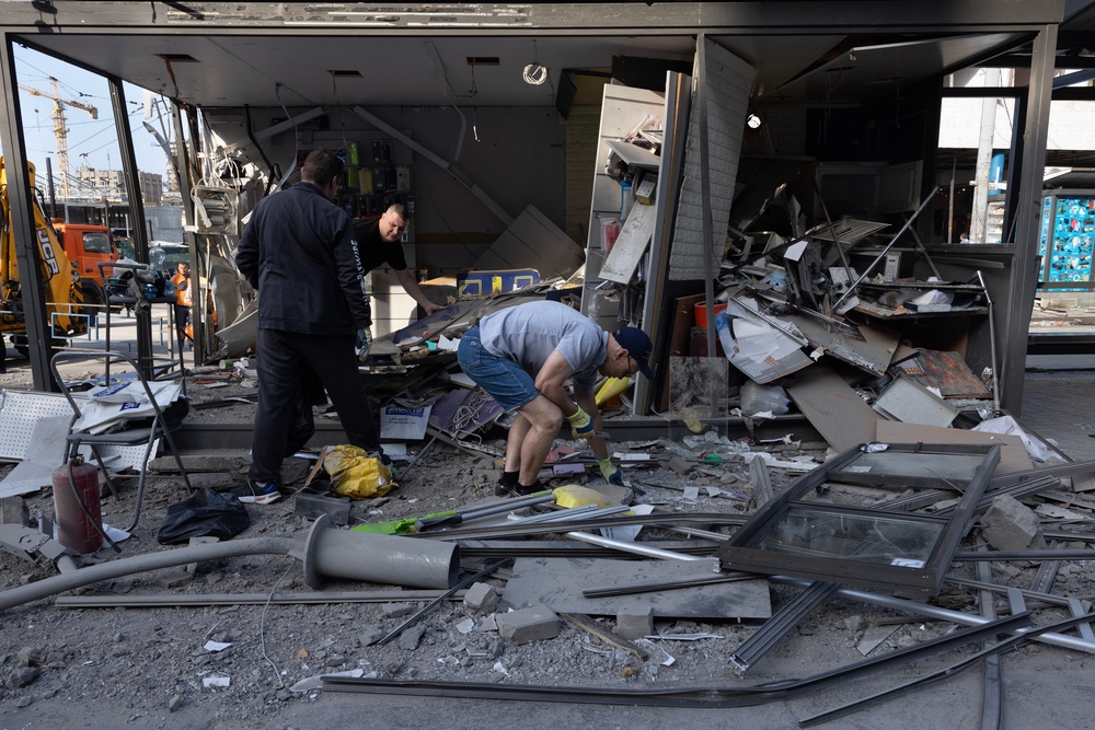 People clean up their small shop after a large-scale attack overnight that left at least one person dead and 14 injured (Getty)
