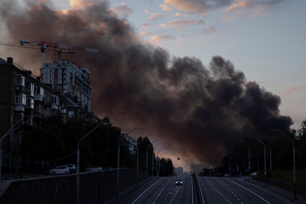 A column of smoke rises over the city as a car drives on a highway following Russian missile strikes, amid Russia’s attack on Ukraine, in Kyiv, Ukraine, July 19, 2026 (Reuters)