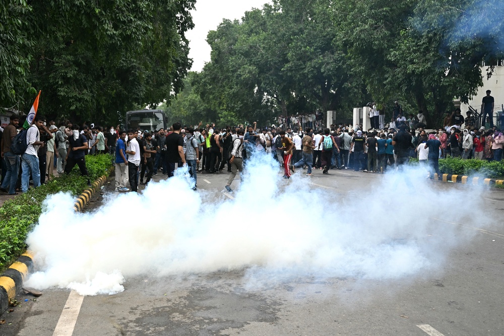 Activists and supporters of the Cockroach Janta Party disperse after police fire teargas during a protest in Delhi (AFP/Getty)