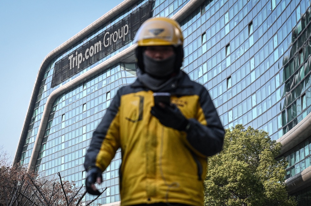 A food delivery driver walks past the headquarters of the Chinese travel agency Trip in Shanghai (AFP/Getty)