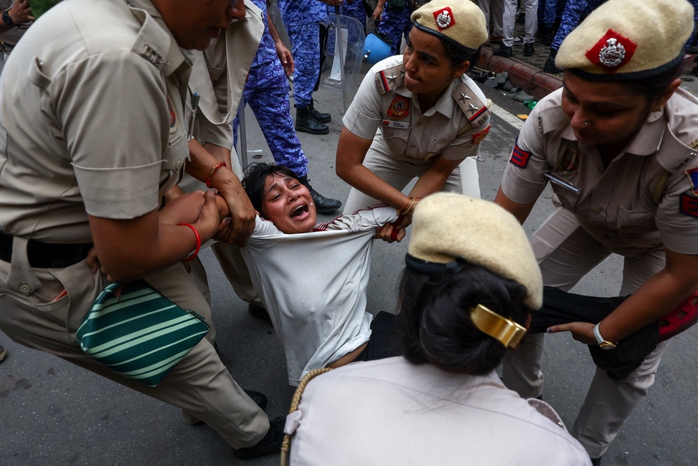 Police officers remove a protester (Reuters)