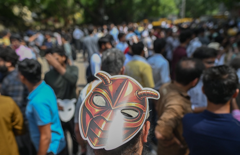 A supporter of CJP wears a cockroach mask during a protest demanding the resignation of the Education Minister over alleged examination paper leaks (Getty Images)