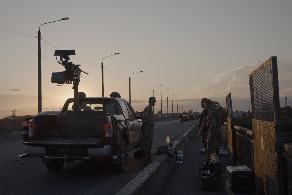 A flatbed truck carrying a large Browning machine gun, its barrel trained towards the sky, aiming at drones (Harry Stourton)