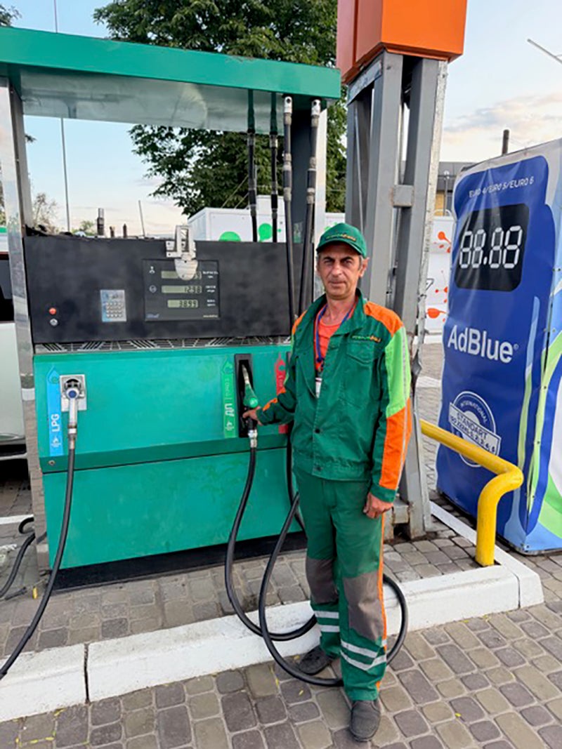 Sergei, 59, a pump attendant, points to shrapnel marks on the kiosk: ‘I look at the sky all day’ (Harry Stourton)