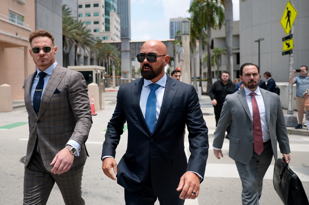 Joseph McBride (C), lead counsel for Andrew and Tristan Tate, along with Justin Waller (L), a friend of the brothers, and Thomas Maniotis (R), co-counsel, exit the C. Clyde Atkins United States Courthouse (Getty)