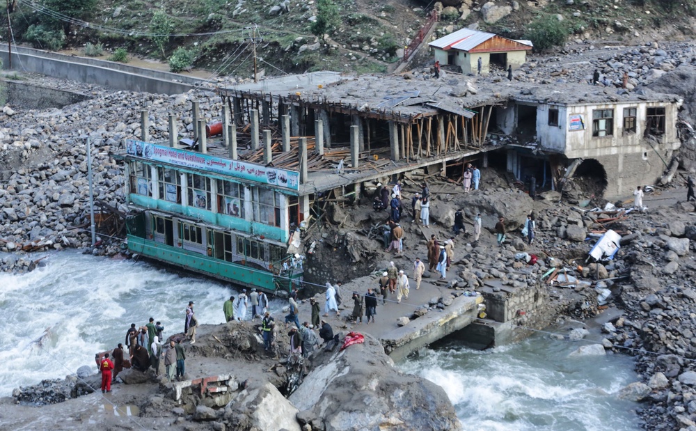 Residents and rescue workers inspect buildings damaged by heavy flooding in the province of Nuristan, Afghanistan (AP)