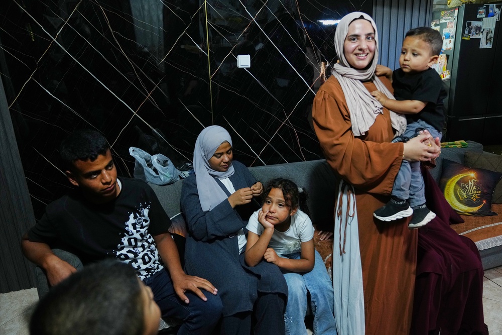 Mais Al-Gharam holds her son as she stands with her siblings from Gaza, who were granted Israeli passports, in her home in Nazareth, Israel, Wednesday, July 8, 2026. (AP Photo/Mahmoud Illean) (Copyright 2026 The Associated Press. All rights reserved)