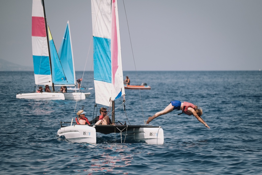 Activities include sailing and kayaking (Peligoni Club)