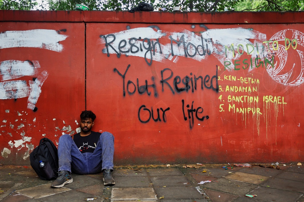 A supporter of India's Cockroach Janata Party (CJP) sits on the ground as he takes rest during ongoing protests, two days after thousands of protesters marched towards parliament (Reuters)