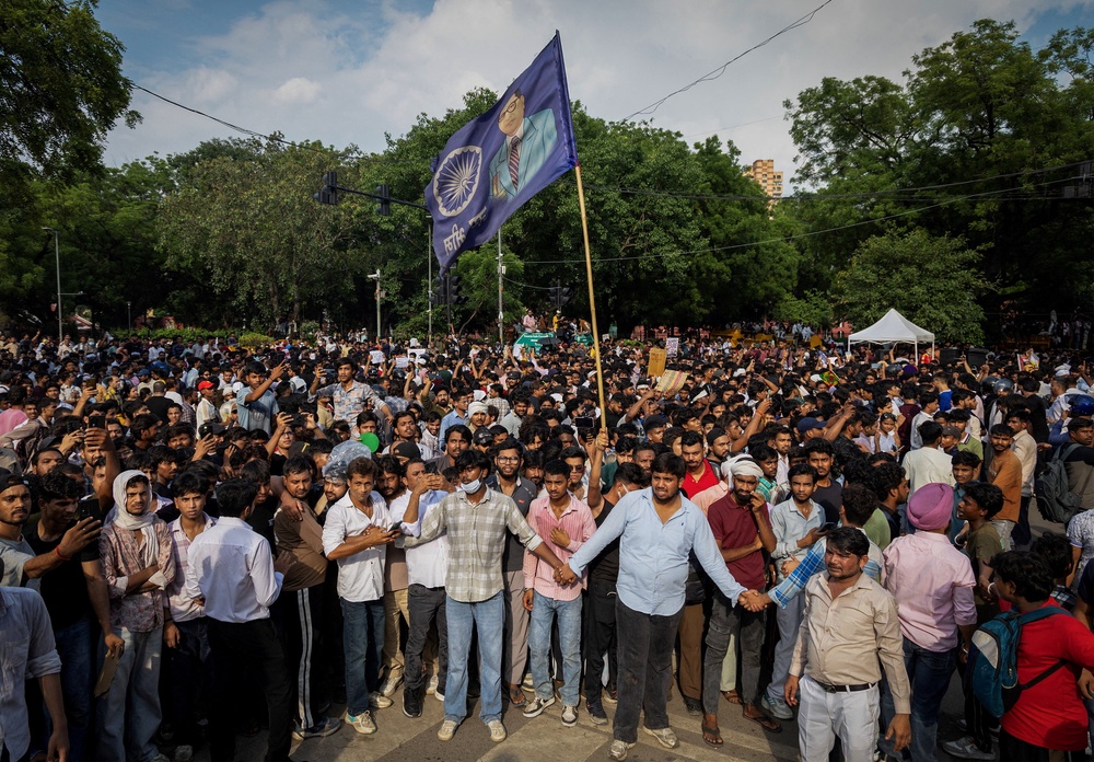 Supporters of India's Cockroach Janata Party (CJP) form a human chain to control demonstrators during the ongoing protests, two days after thousands of protesters marched towards parliament (Reuters)