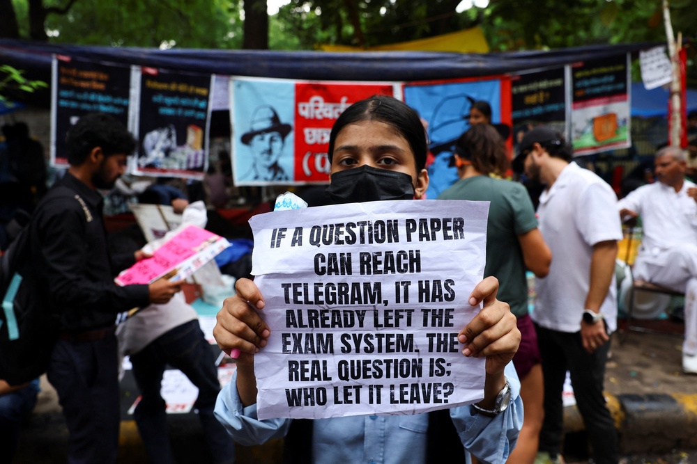 A supporter of India's Cockroach Janata Party (CJP) holds a sign during the ongoing protests, a few days after thousands of protesters marched towards parliament (Reuters)