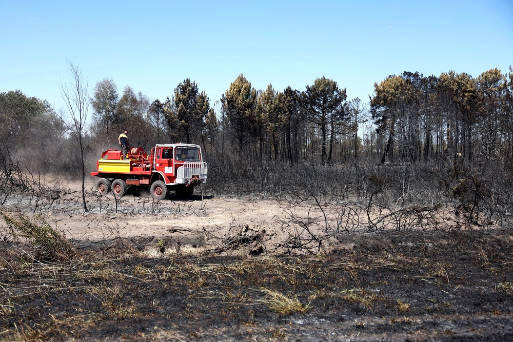 Locals drive an old fire truck at the site where a wildfire broke out on July 21 (AFP/Getty)