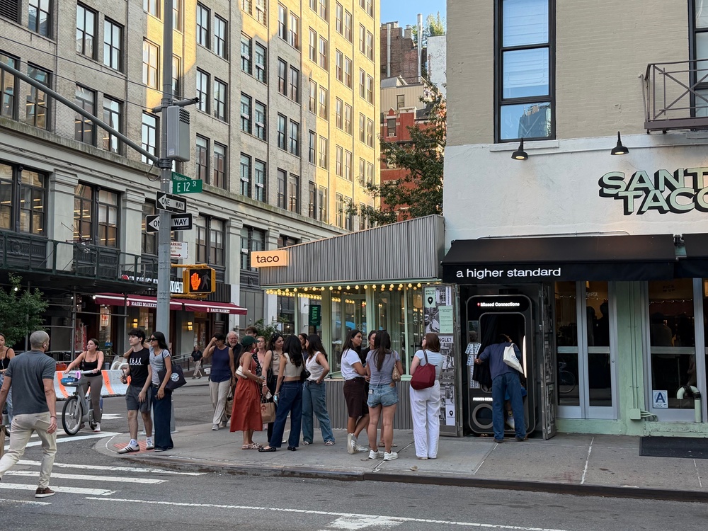 Hopeful singles wait in line for the ‘Missed Connections’ photobooth on East 12th Street and University Place in Manhattan (Ellie Muir / The Independent)
