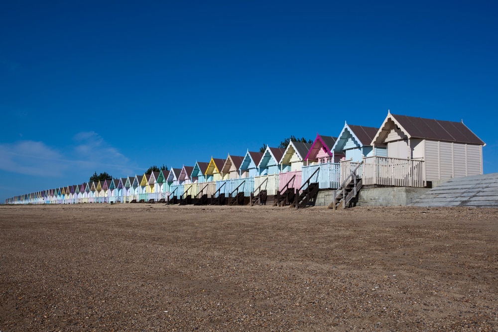 Beach Huts against a blue sky at West Mersea, Essex, England (Getty/iStock)