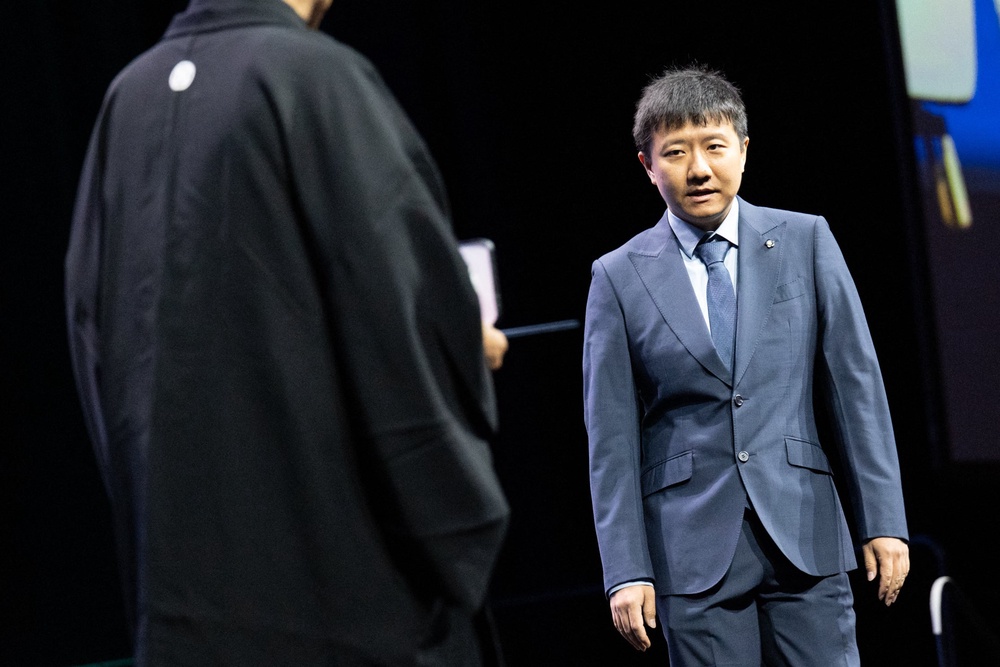 Chinese mathematician Yu Deng walks onstage as he is awarded the 2026 Fields Medal during the International Congress of Mathematicians in Philadelphia (AFP/Getty)