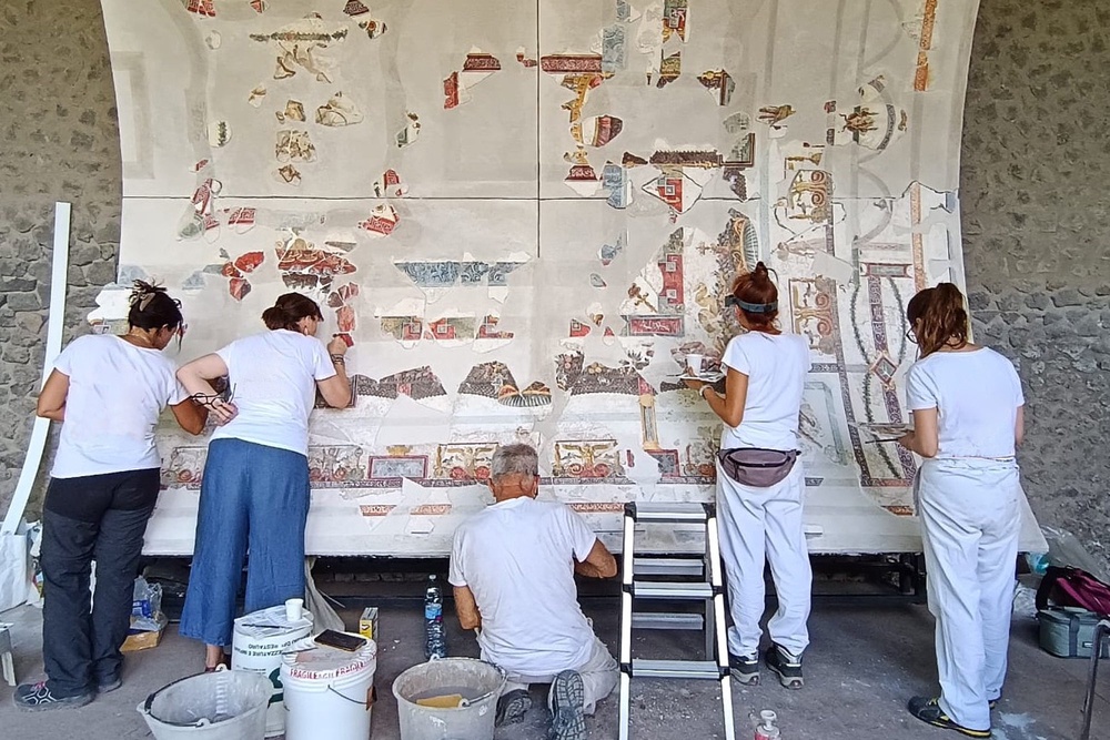 Experts work on part of the restored ceiling vault of the Bakery House