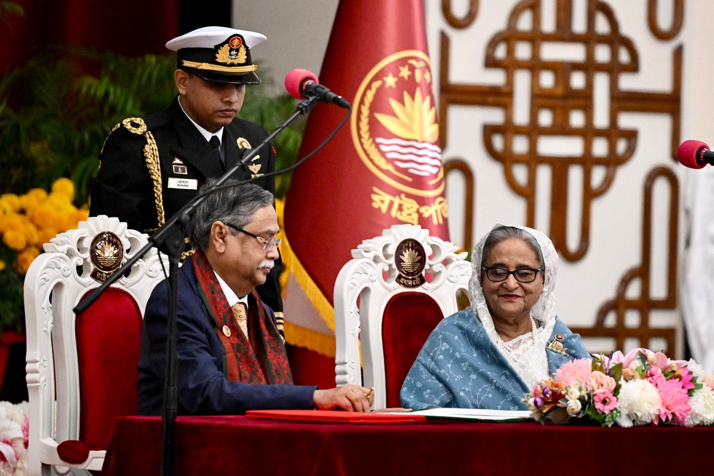 File. Bangladesh president Mohammed Shahabuddin (C) watches as prime minister Sheikh Hasina (R) signs documents after being sworn in for her fifth term at the Presidential Palace in Dhaka on 11 January 2024 (AFP/Getty)