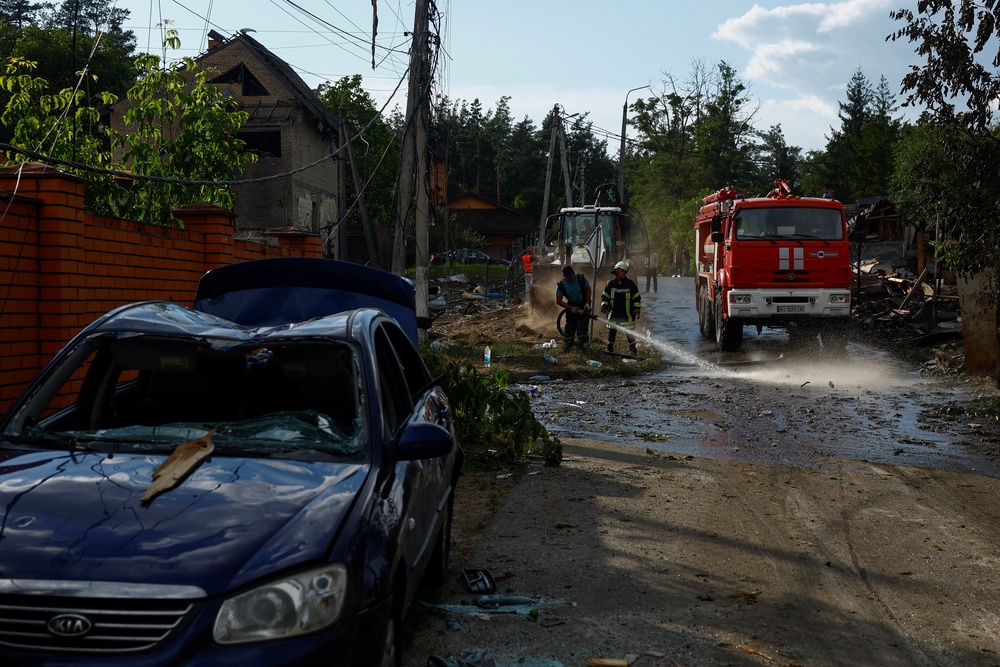 Firefighters remove debris from a street at the site of a residential area hit by a Russian missile strike in the Kyiv region, Ukraine, 24 July 2026 (Reuters)