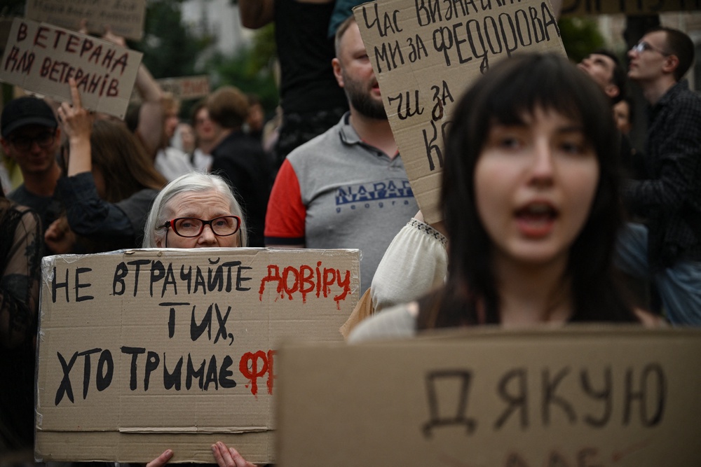 Attendees hold placards and chant slogans during a demonstration to protest against Ukraine's President's decision to dismiss Ukraine's former Defence Minister, in Kyiv on 24 July 2026 (AFP/Getty)