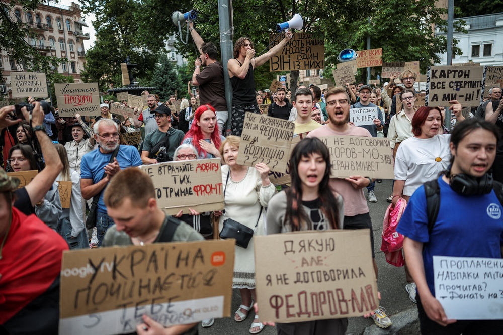 Participants hold signs and shout slogans during a rally to protest against Ukrainian President Volodymyr Zelenskiy's decision to replace Mykhailo Fedorov as Defence Minister, amid Russia's attack on Ukraine, in Kyiv, Ukraine, July 24, 2026. (Reuters)