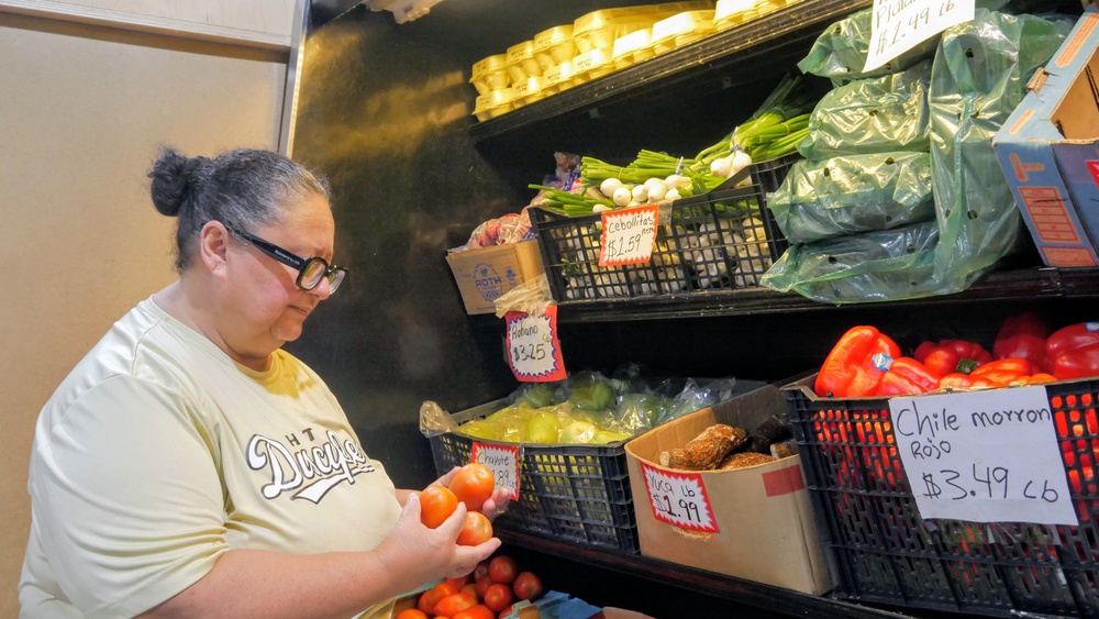 Ada Torres holds tomatoes while shopping for produce in Cleveland, Texas (AP)