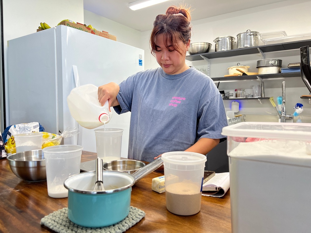 Pastry chef Amanda Tabadero pours milk into a plastic container while preparing ingredients for maritozzi at Creature Coffeeshop (AP)