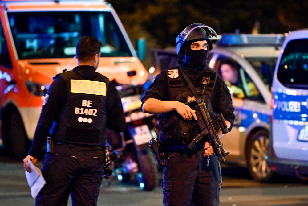 Armed police stand near the scene where one person was killed and around 16 injured after a car struck people on the outskirts of the Christopher Street Day (CSD) parade in Berlin, on 25 July 2026 (AFP/Getty)